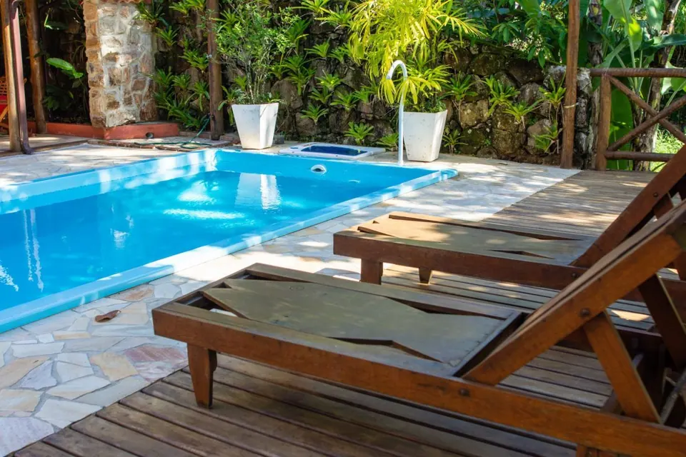 Espreguiçadeiras de madeira no deck ao lado da piscina da Pousada Casa Bonita, Ilha Grande
